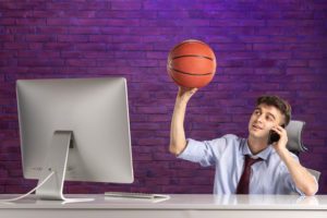 front-view-office-worker-office-desk-holding-basketball-talking-phone-scaled
