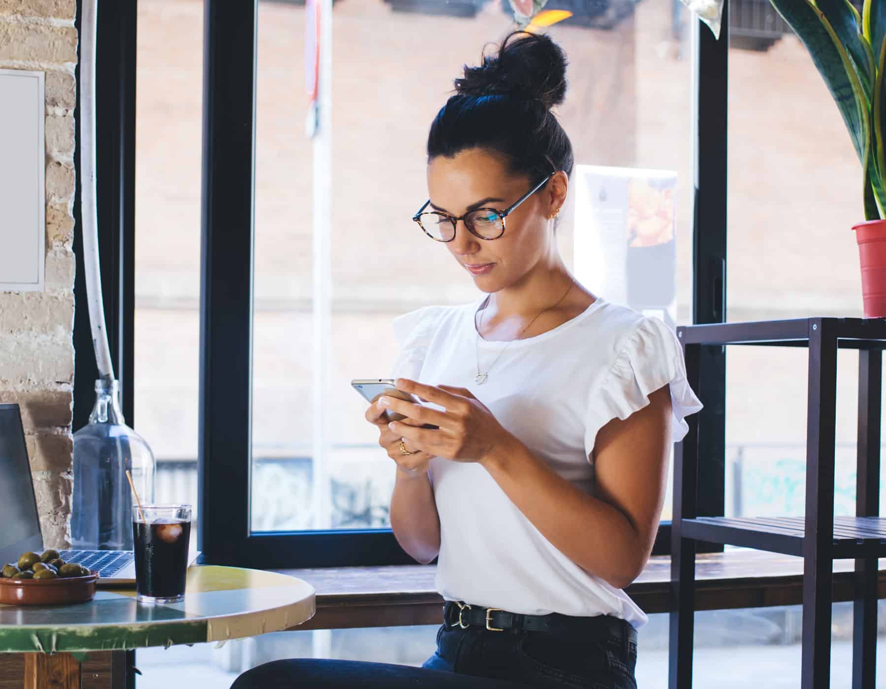 Woman sending personal 1 to 1 text message in a coffee shop