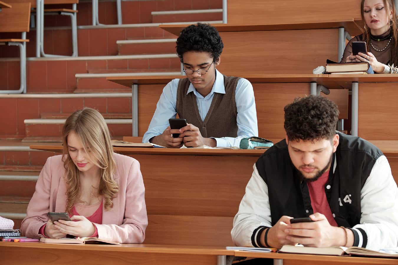 Students in university classroom receiving text message