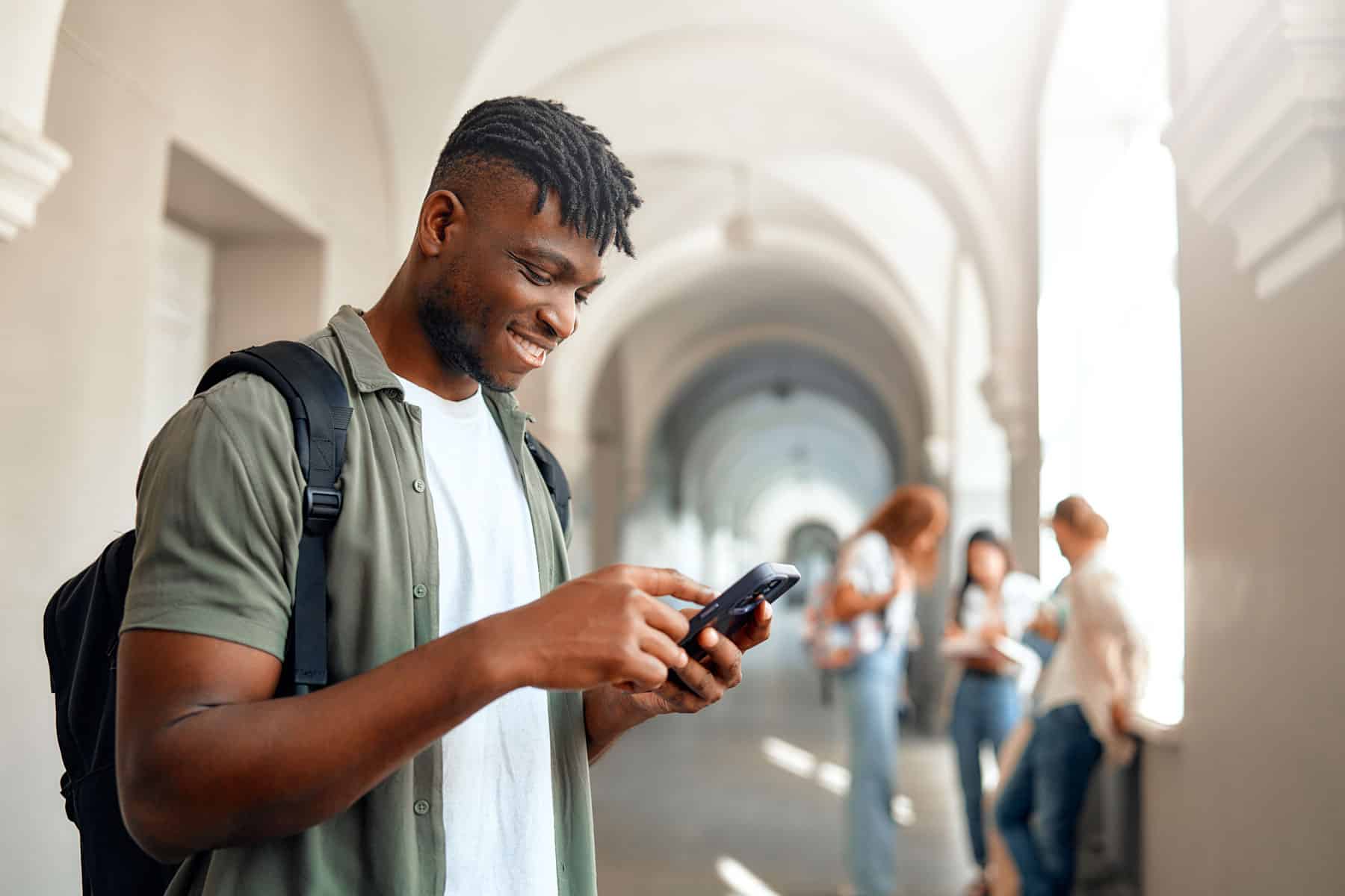 Student reading interactive text message from his unversity