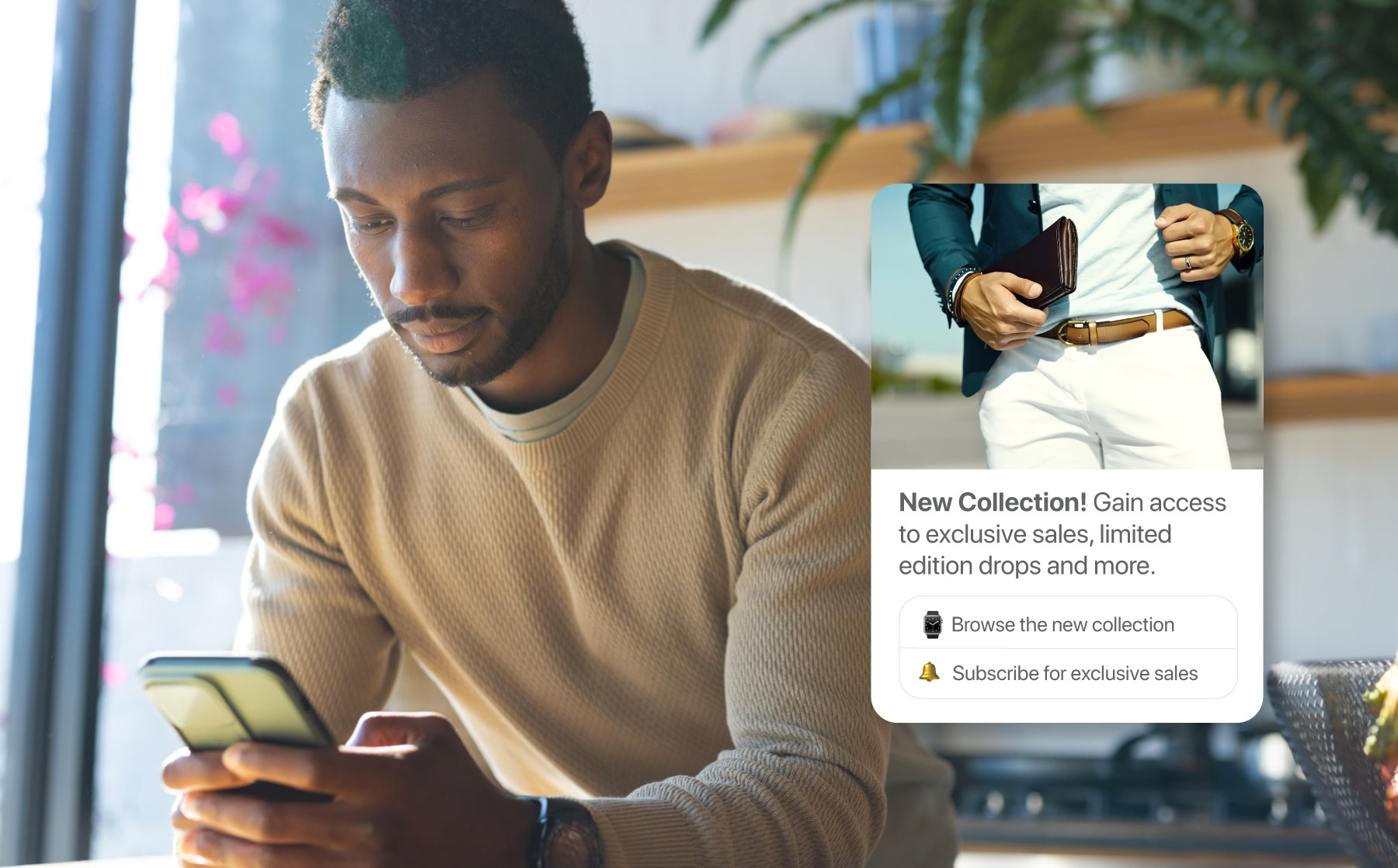Man in his kitchen reading an RCS message on his phone